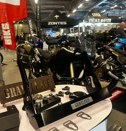 Close-up of a motorcycle part with 'Gravelence' branding at a trade show.